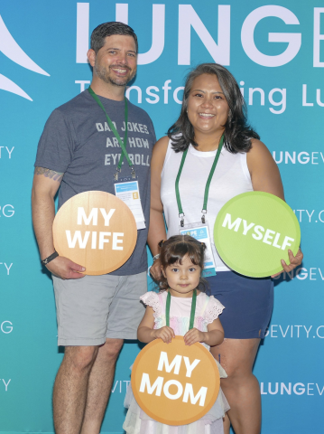 May smiling in a photo with her husband and daughter